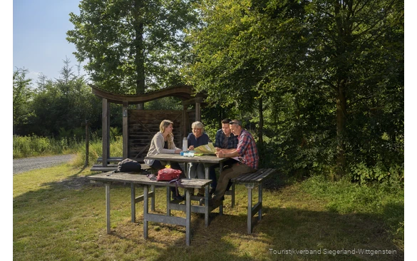 Wandergruppe sitzt an einer Rothaarsteig-Vesperinsel