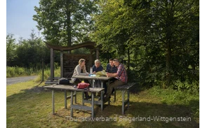 Wandergruppe sitzt an einer Rothaarsteig-Vesperinsel