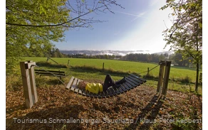 Frau liegt bei Sonnenschein in einer Rothaarsteig-Hängematte