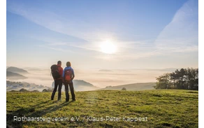 Wanderndes Pärchen auf dem Rothaarsteig schaut in den Sonnenaufgang